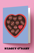 Card with heart-shaped chocolate candy design and text on a pink background, featuring the brand 'Stacey O'Nary'.