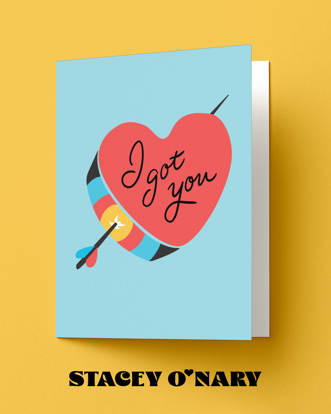 Greeting card with heart and arrow design on a yellow background, featuring the brand 'Stacey O'Nary'.
